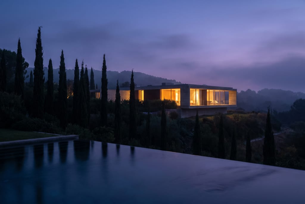 Maison au crépuscule Maison contemporaine éclairée au crépuscule, jardin sombre et baies vitrées